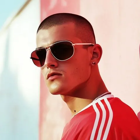 Federico Portesto mit Sonnenbrille und rotem Trikot an einer roten Wand